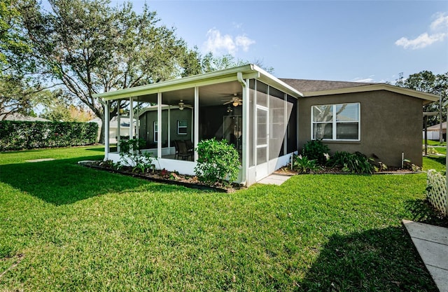 view of side of property with a sunroom, ceiling fan, and a yard