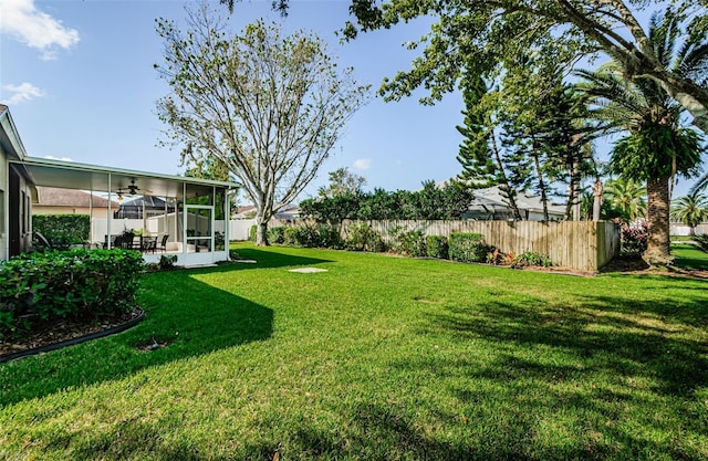 view of yard with a sunroom and ceiling fan