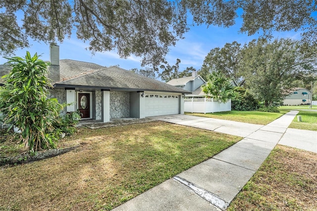 single story home featuring a front lawn and a garage