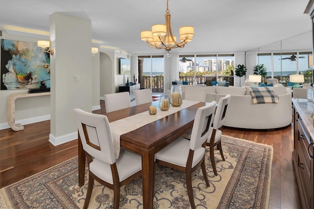 dining space with ceiling fan with notable chandelier and dark hardwood / wood-style floors