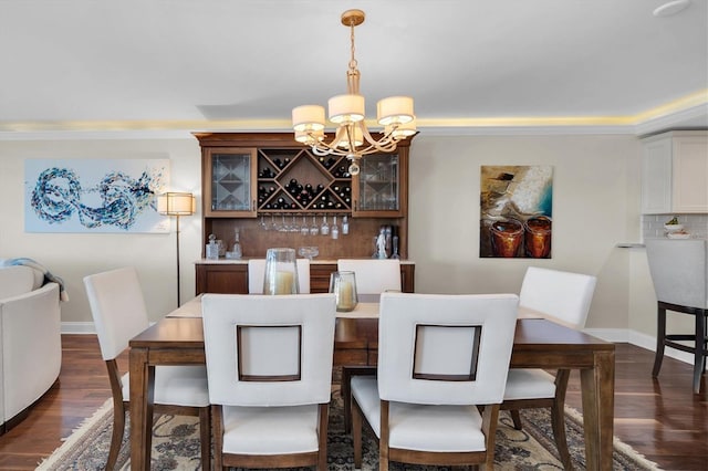 dining room with crown molding, dark wood-type flooring, and an inviting chandelier