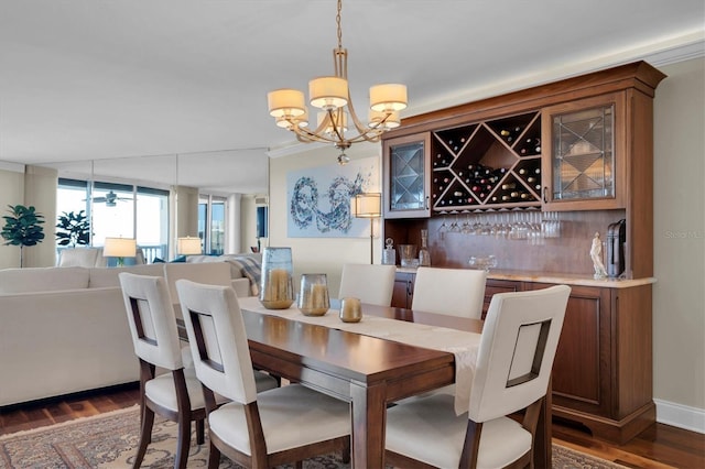 dining room with dark wood-type flooring, ceiling fan with notable chandelier, and ornamental molding