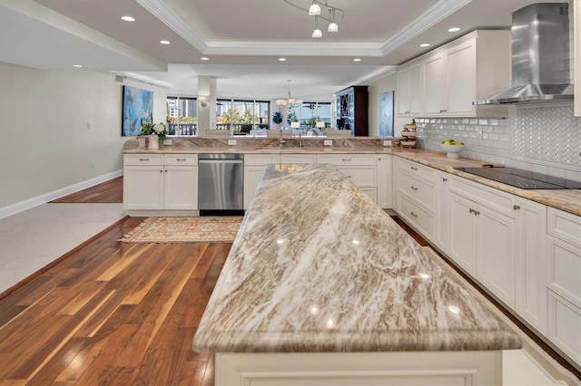 kitchen with a center island, wall chimney range hood, kitchen peninsula, and black electric cooktop