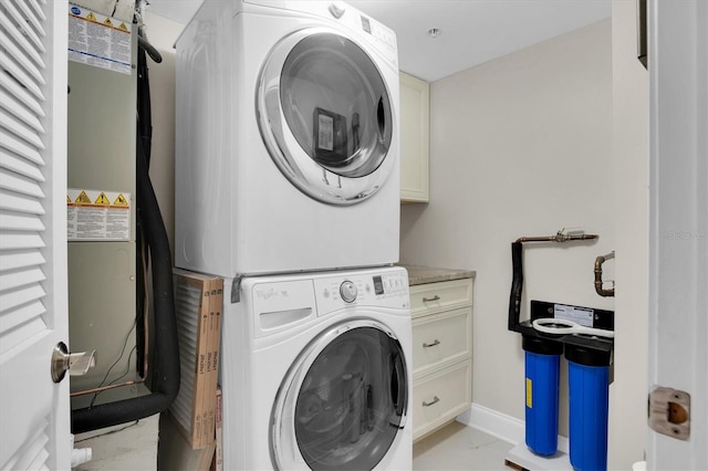 laundry room with cabinets and stacked washing maching and dryer