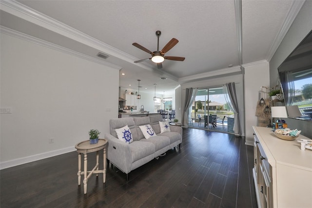 living room featuring ceiling fan, dark wood-type flooring, a textured ceiling, and ornamental molding