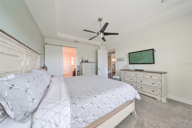 carpeted bedroom featuring a barn door and ceiling fan