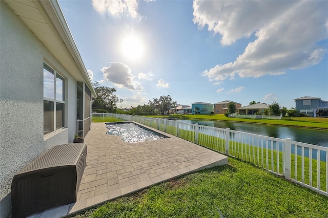 view of pool with a patio area, a water view, and a yard