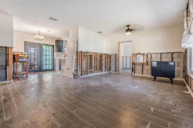 interior space with french doors, dark hardwood / wood-style flooring, and ceiling fan with notable chandelier