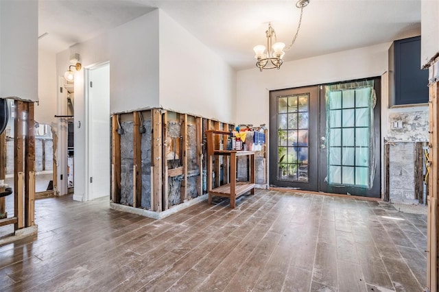 entryway featuring a notable chandelier, dark hardwood / wood-style flooring, and french doors