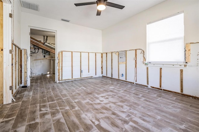 empty room with hardwood / wood-style flooring, ceiling fan, and a healthy amount of sunlight