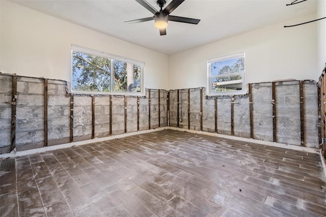 unfurnished room with ceiling fan and dark wood-type flooring