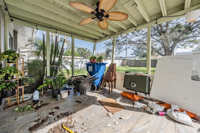 sunroom / solarium featuring beamed ceiling and ceiling fan