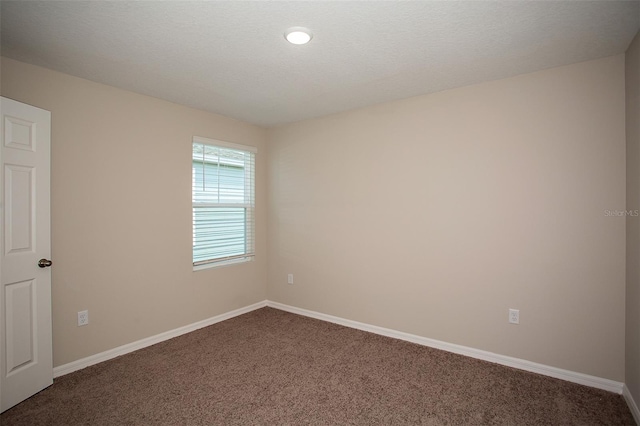 carpeted spare room featuring a textured ceiling