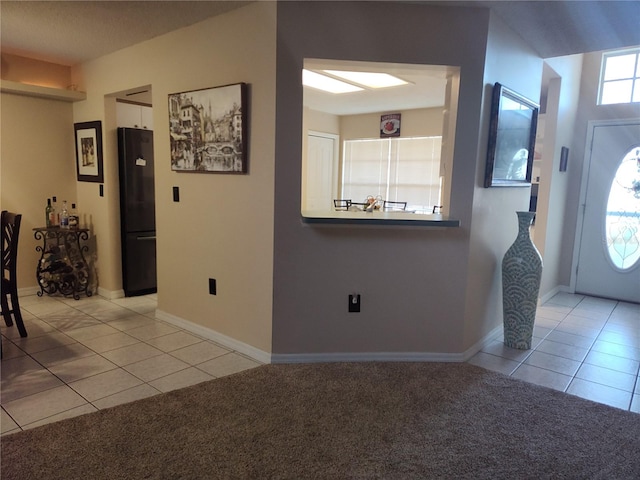 foyer featuring light colored carpet