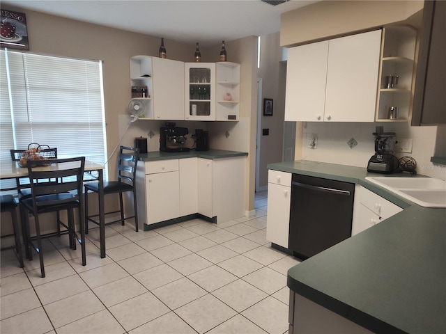 kitchen featuring decorative backsplash, stainless steel dishwasher, sink, light tile patterned floors, and white cabinetry