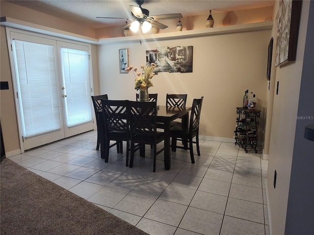 tiled dining room with a textured ceiling and ceiling fan