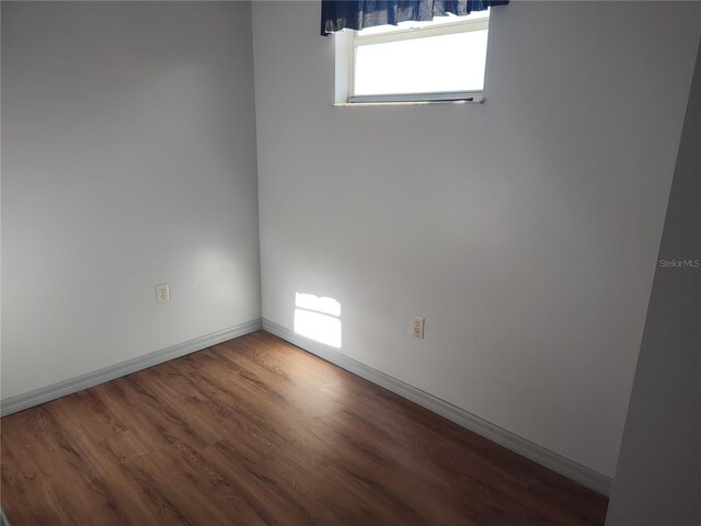 empty room with dark hardwood / wood-style floors