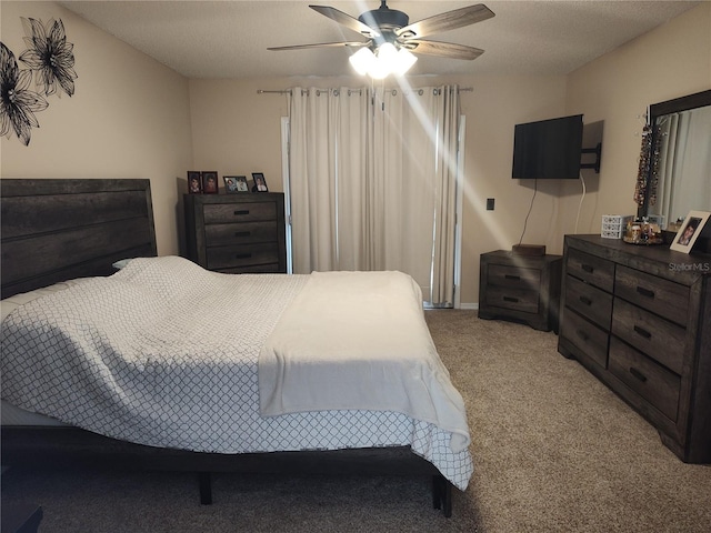 carpeted bedroom featuring ceiling fan and a textured ceiling