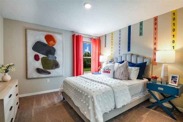 bedroom featuring a textured ceiling and dark carpet