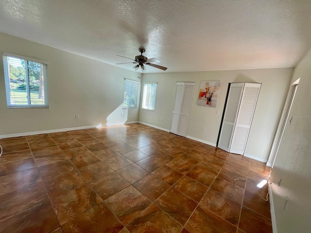 spare room featuring ceiling fan and a textured ceiling