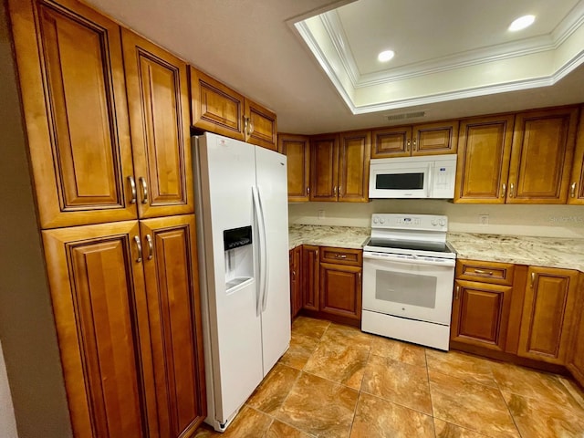 kitchen with light stone countertops, white appliances, crown molding, and a tray ceiling