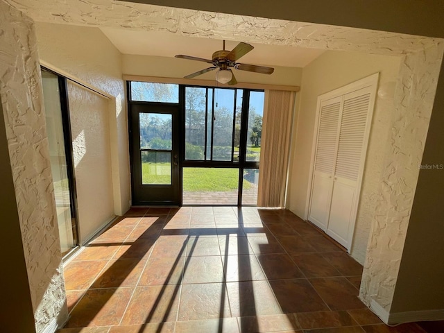 interior space featuring dark tile patterned flooring and ceiling fan