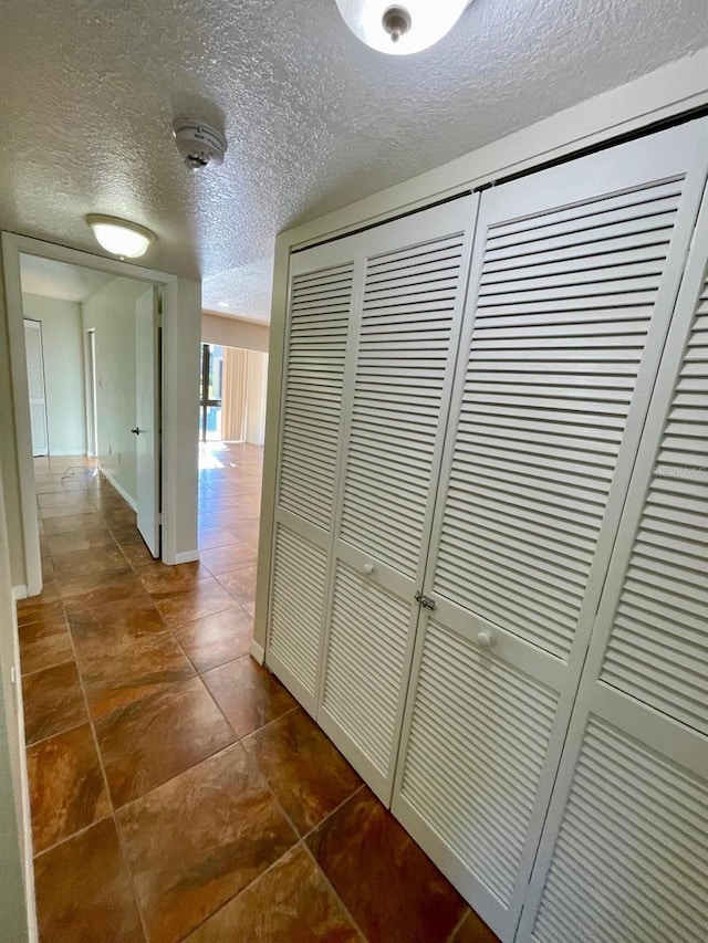 hallway with a textured ceiling