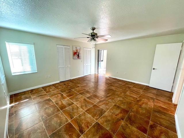 unfurnished room with a textured ceiling and ceiling fan