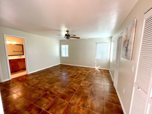 spare room featuring ceiling fan and a textured ceiling