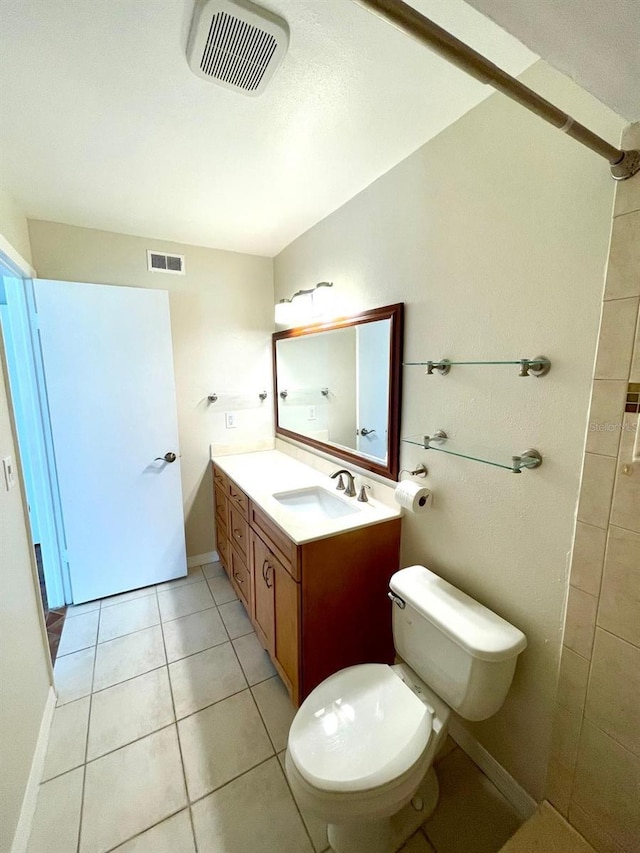 bathroom with toilet, vanity, and tile patterned floors