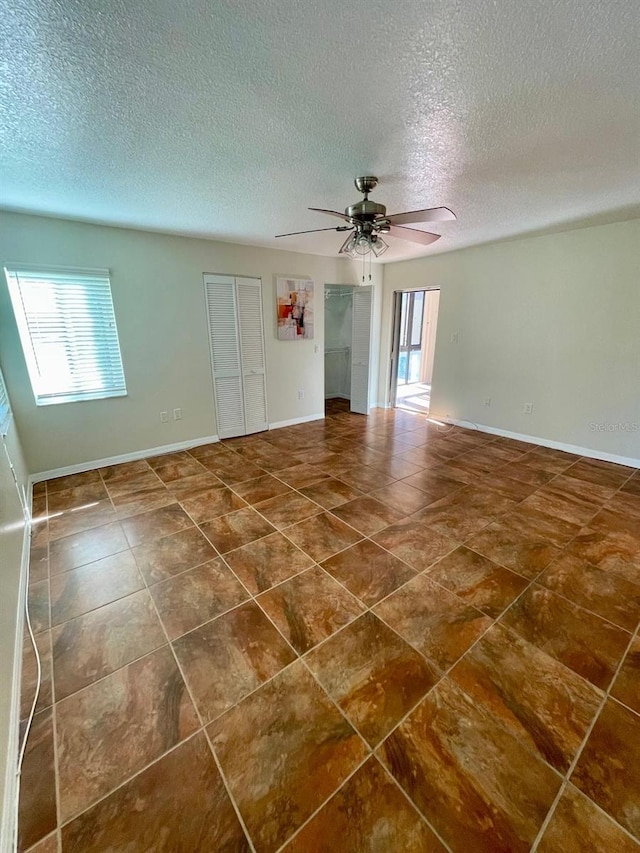 empty room featuring ceiling fan and a textured ceiling