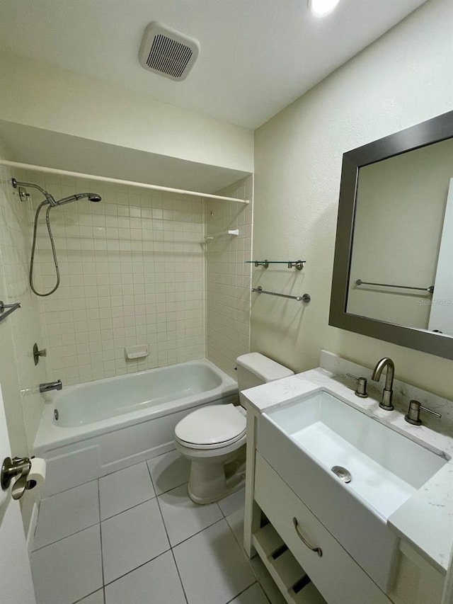 full bathroom featuring tiled shower / bath, tile patterned flooring, vanity, and toilet