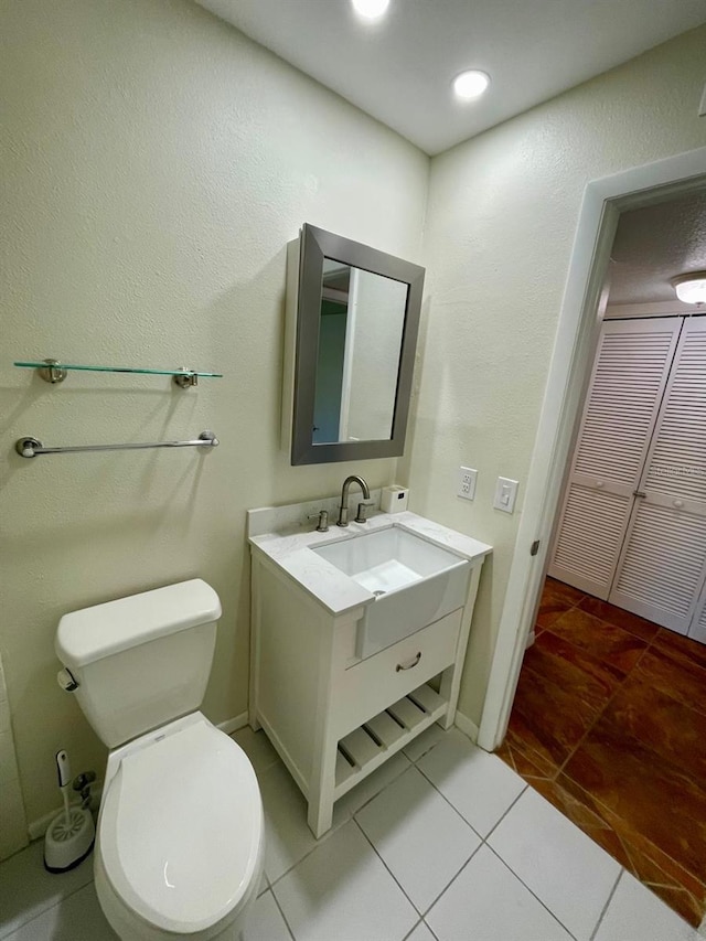 bathroom featuring tile patterned flooring, vanity, and toilet