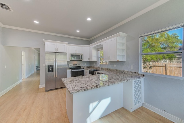 kitchen featuring kitchen peninsula, white cabinets, light hardwood / wood-style floors, and appliances with stainless steel finishes