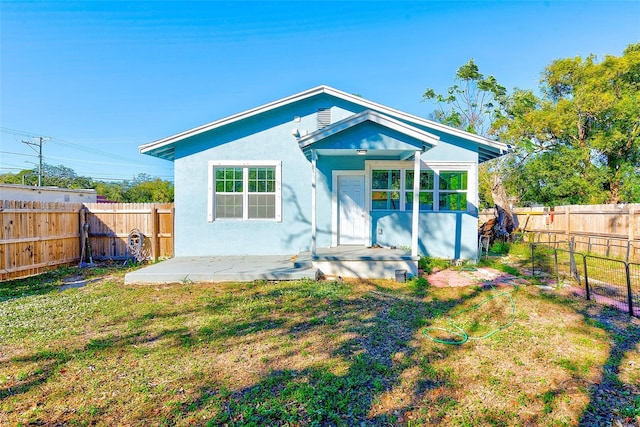 view of front of home with a patio and a front lawn