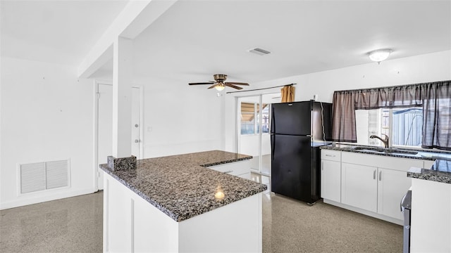 kitchen with sink, ceiling fan, white cabinetry, a center island, and black fridge