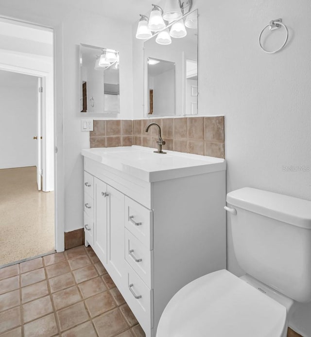 bathroom featuring tasteful backsplash, vanity, and toilet