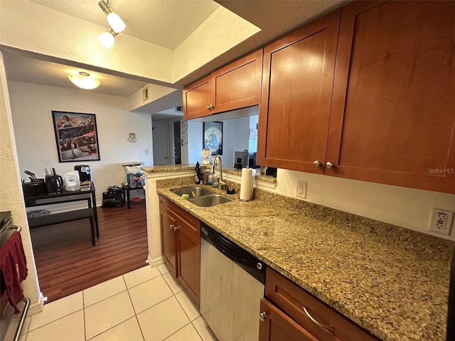 10200 Gandy Blvd N Unit 921, Saint Petersburg, FL 33702 - kitchen with stainless steel dishwasher, a sink, light tile patterned floors, brown cabinets, and a textured ceiling