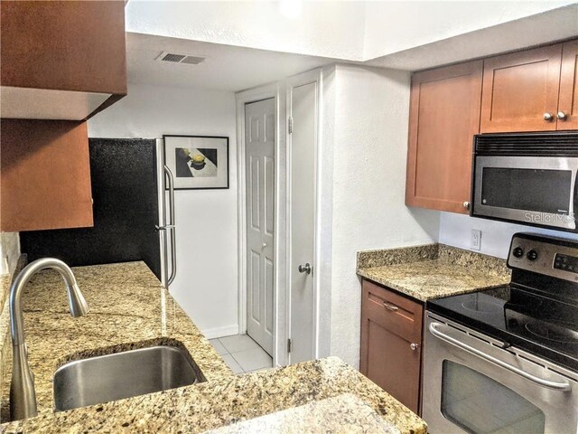 10200 Gandy Blvd N Unit 921, Saint Petersburg, FL 33702 - kitchen featuring appliances with stainless steel finishes, a sink, tile patterned floors, and light stone countertops