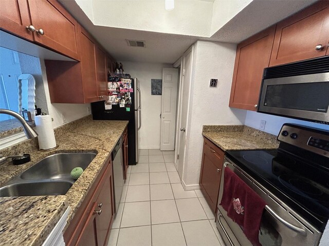 10200 Gandy Blvd N Unit 921, Saint Petersburg, FL 33702 - kitchen with stainless steel appliances, a sink, light tile patterned floors, baseboards, and light stone counters