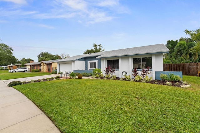 single story home featuring a garage and a front lawn