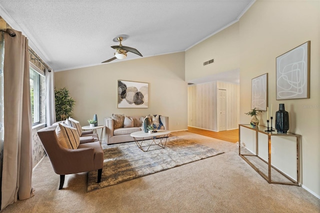 living room featuring ceiling fan, crown molding, light colored carpet, a textured ceiling, and vaulted ceiling