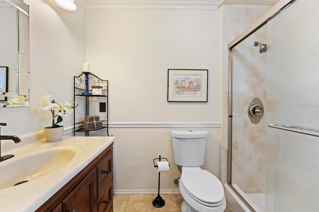 bathroom with tile patterned floors, crown molding, toilet, vanity, and a shower with shower door