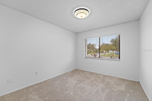 carpeted spare room with a textured ceiling