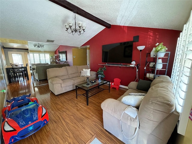 living room featuring a chandelier, wood-type flooring, a textured ceiling, and vaulted ceiling with beams