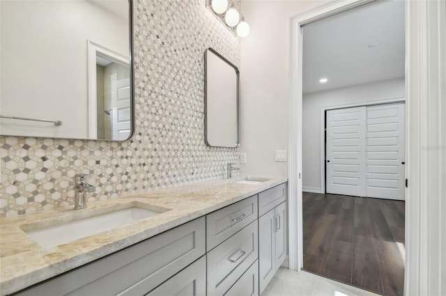 bathroom with hardwood / wood-style floors, vanity, and tasteful backsplash