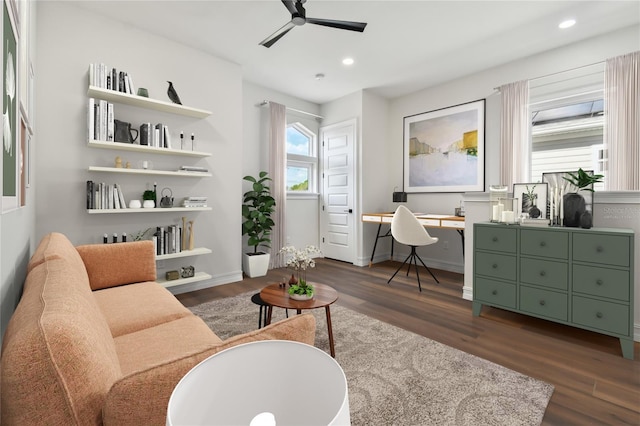 living area featuring ceiling fan and dark hardwood / wood-style flooring