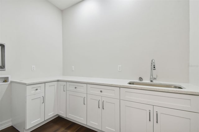 laundry room featuring hookup for a washing machine, cabinets, sink, and dark wood-type flooring