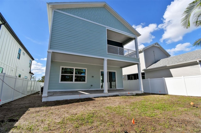 rear view of property with a lawn and a patio