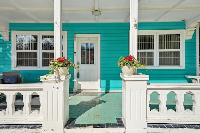 view of exterior entry featuring covered porch